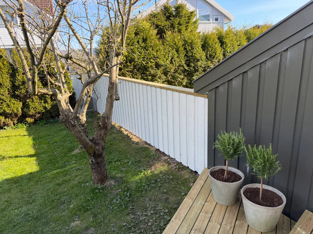 Ny hvit levegg og terrasse med trær i krukker