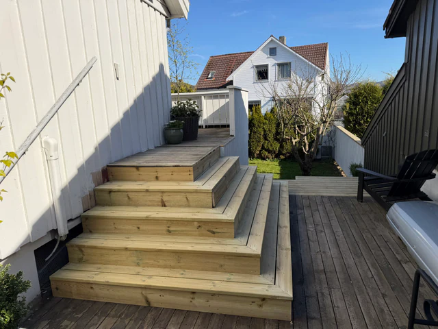 Ny terrassetrapp i trykkimpregnert tre med planter i krukker