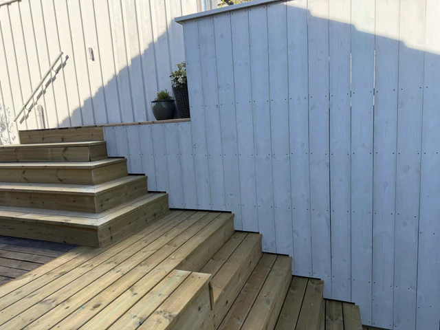 Nye trappetrinn langs hvit kledd levegg
