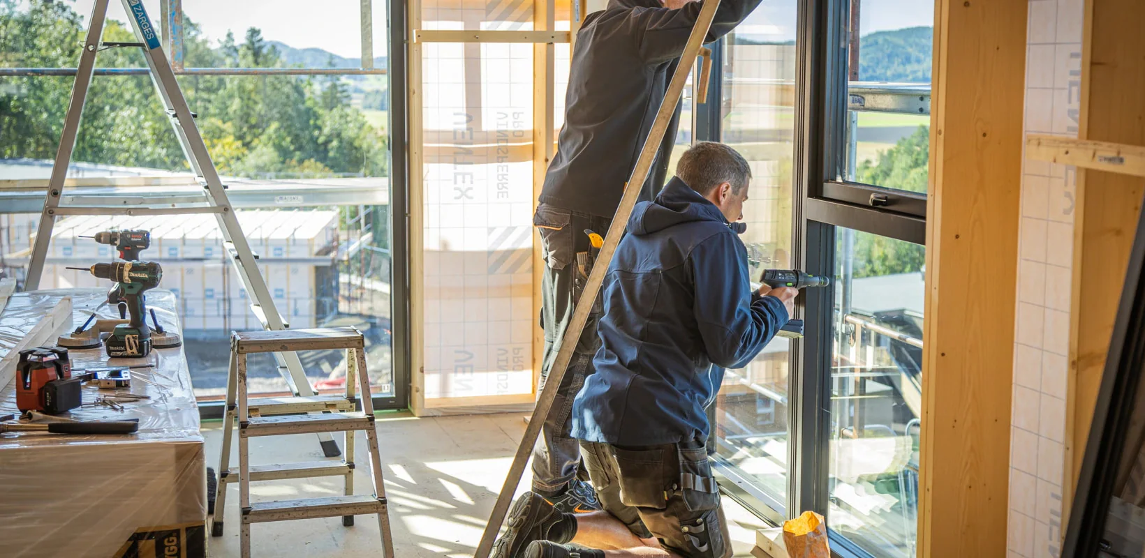 Håndverkere monterer vinduer i bygg under rehabilitering
