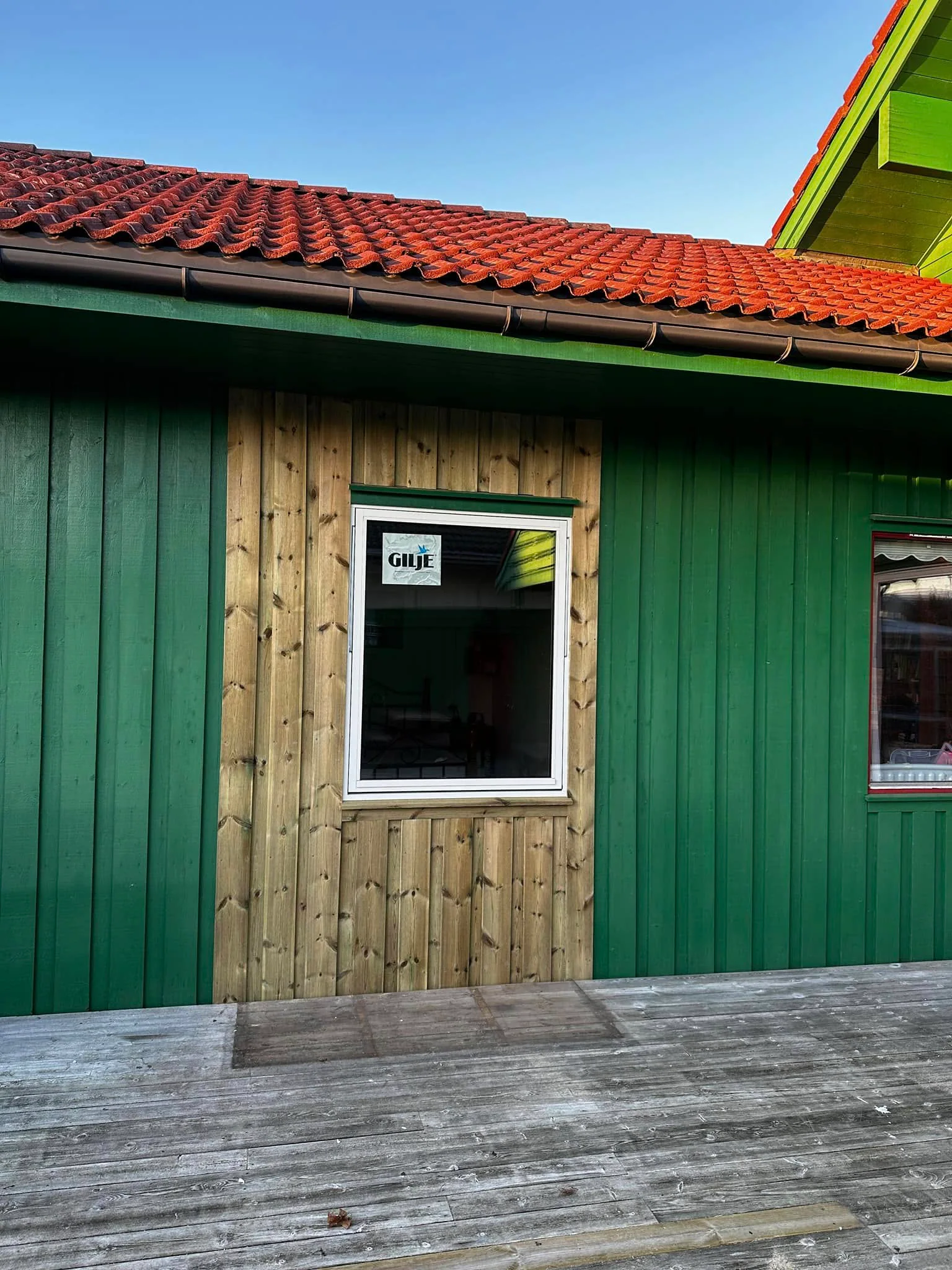 Nytt vindu montert i vegg med grønn og ubehandlet trekledning